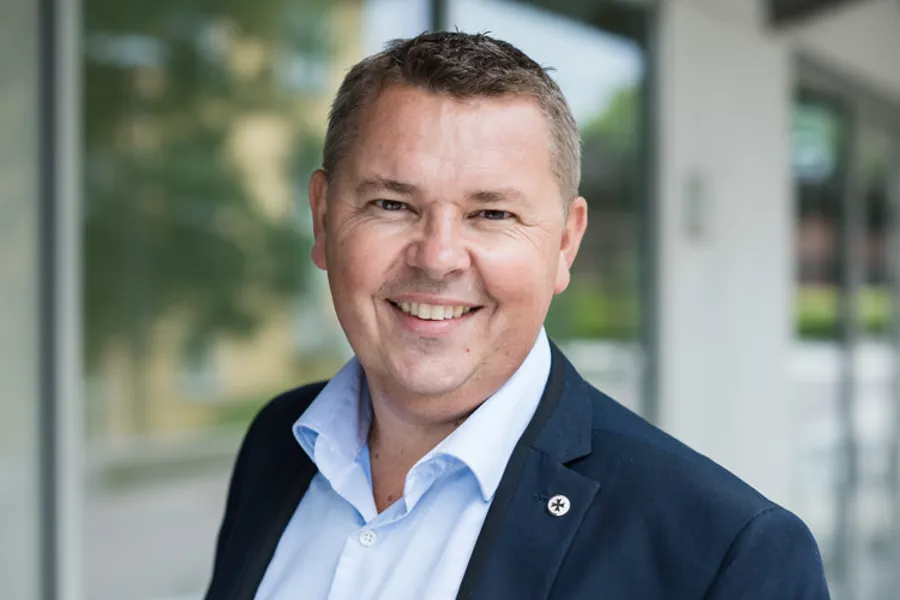 En mann som smiler til kameraet