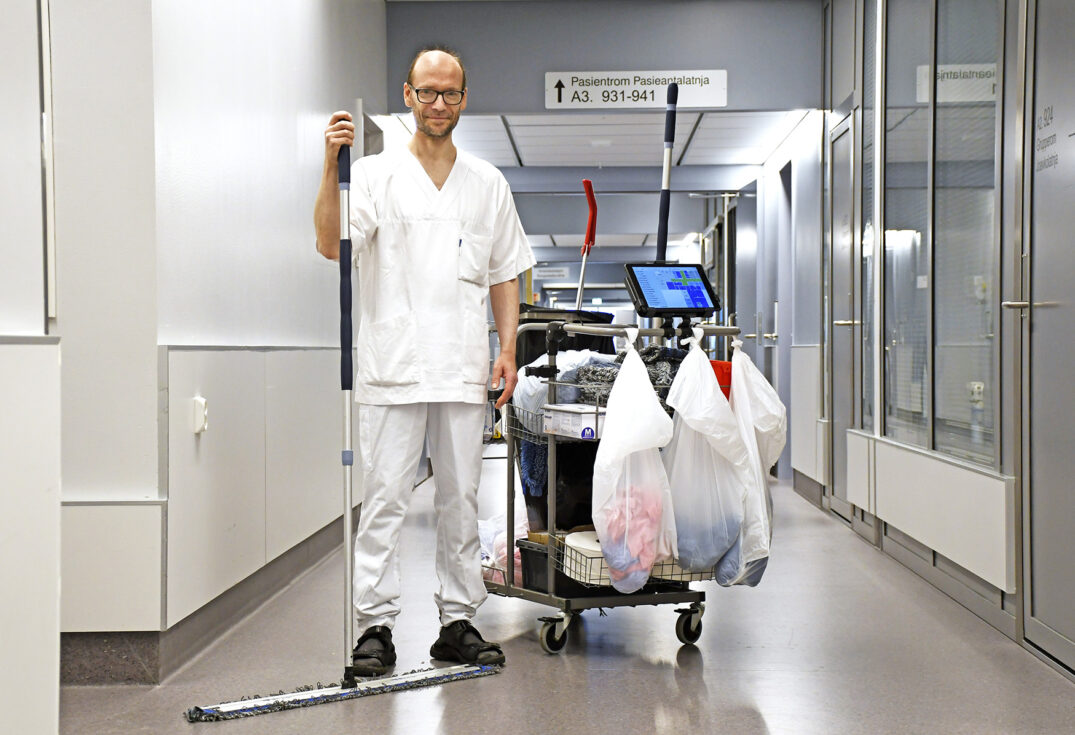 Høy mann med rengjøringstralle