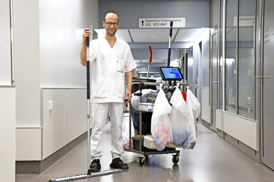 Høy mann med rengjøringstralle