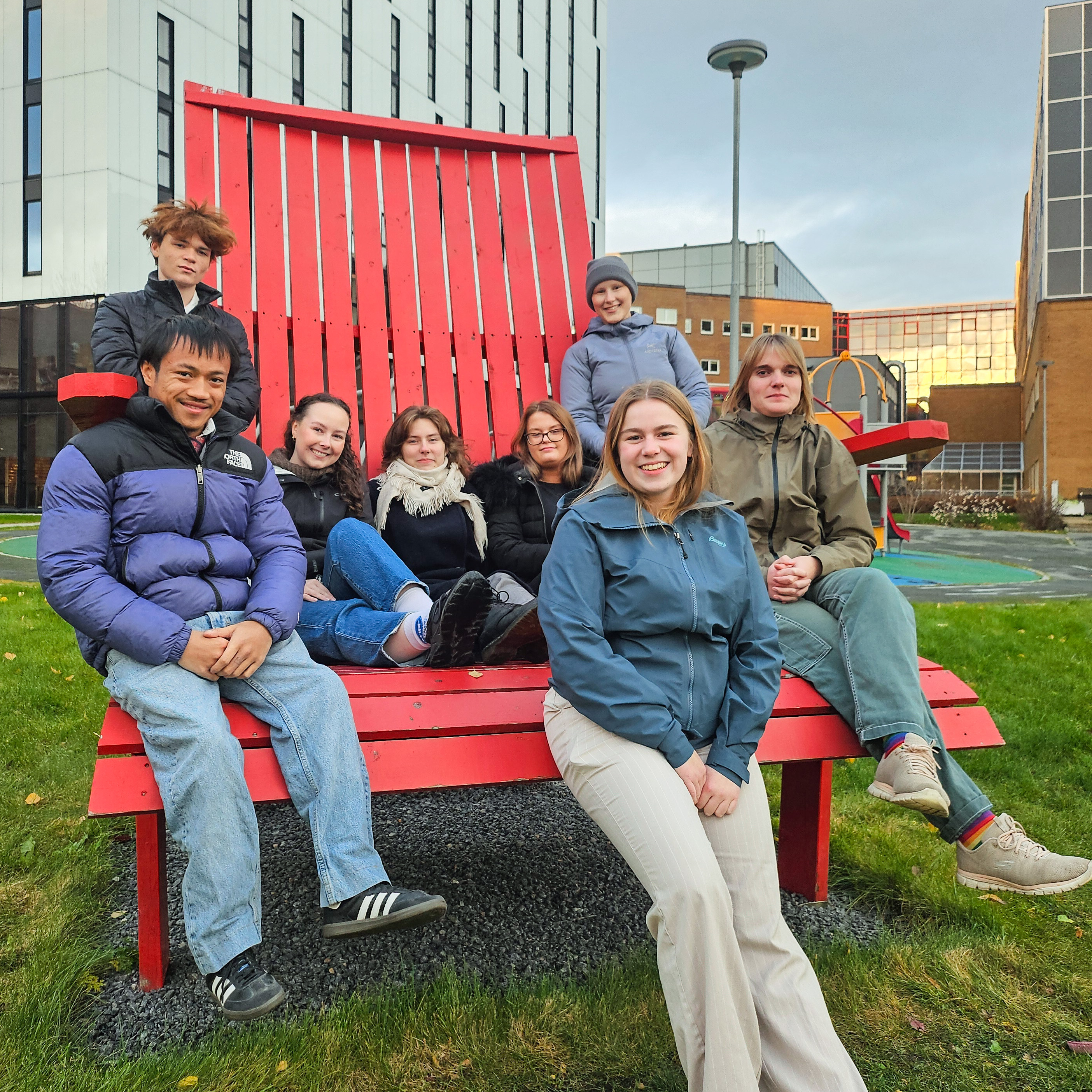 En gruppe mennesker som sitter på en benk