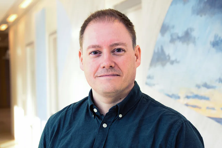 En mann som smiler til kameraet