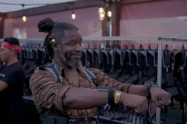 Farget mann som viser fram armene med håndleddsutstyr