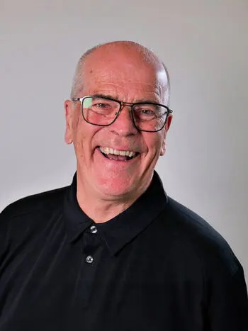 Blid mann med briller og svart skjorte