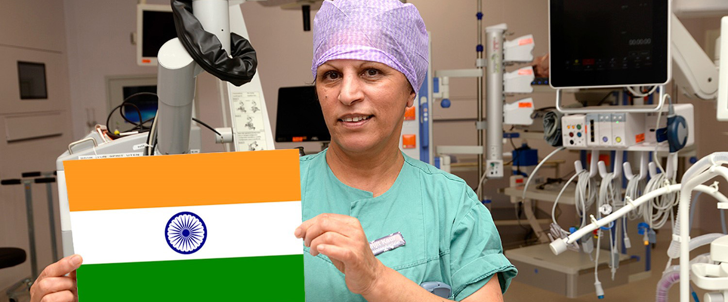 En person iført blå skjorte og en lilla hatt som holder en gul eske