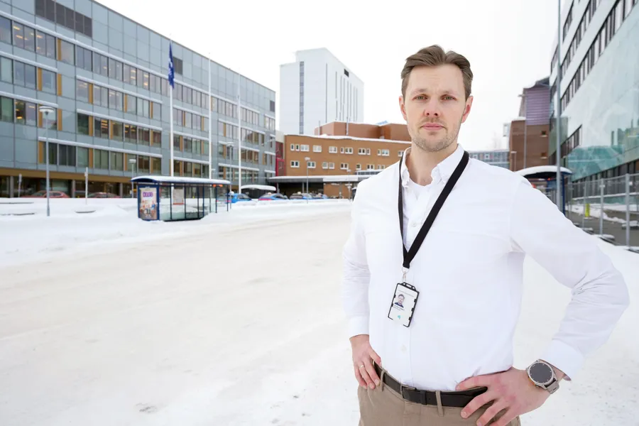 En mann iført hvit frakk og stetoskop står i snøen