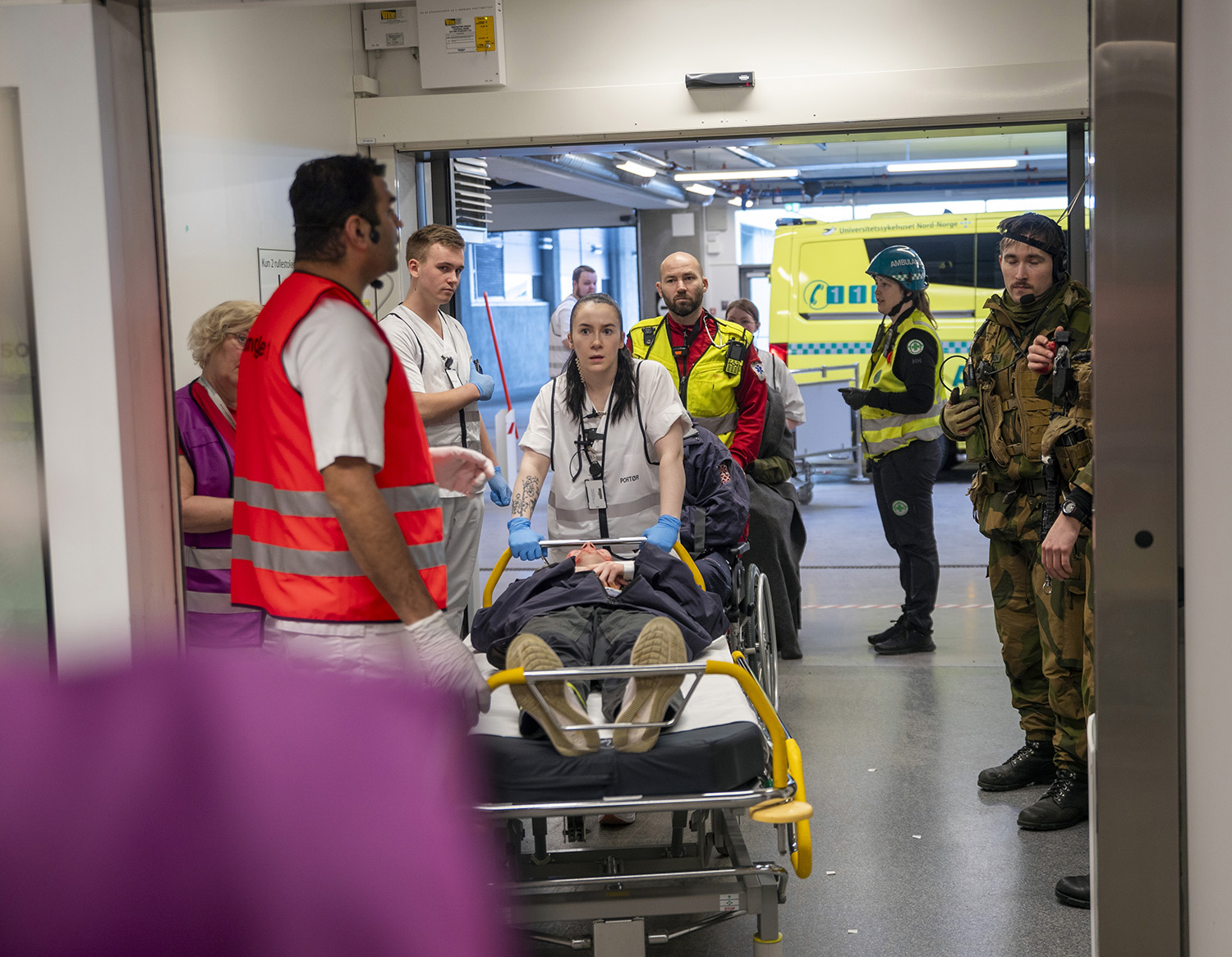 En gruppe mennesker som står rundt en person i rullestol