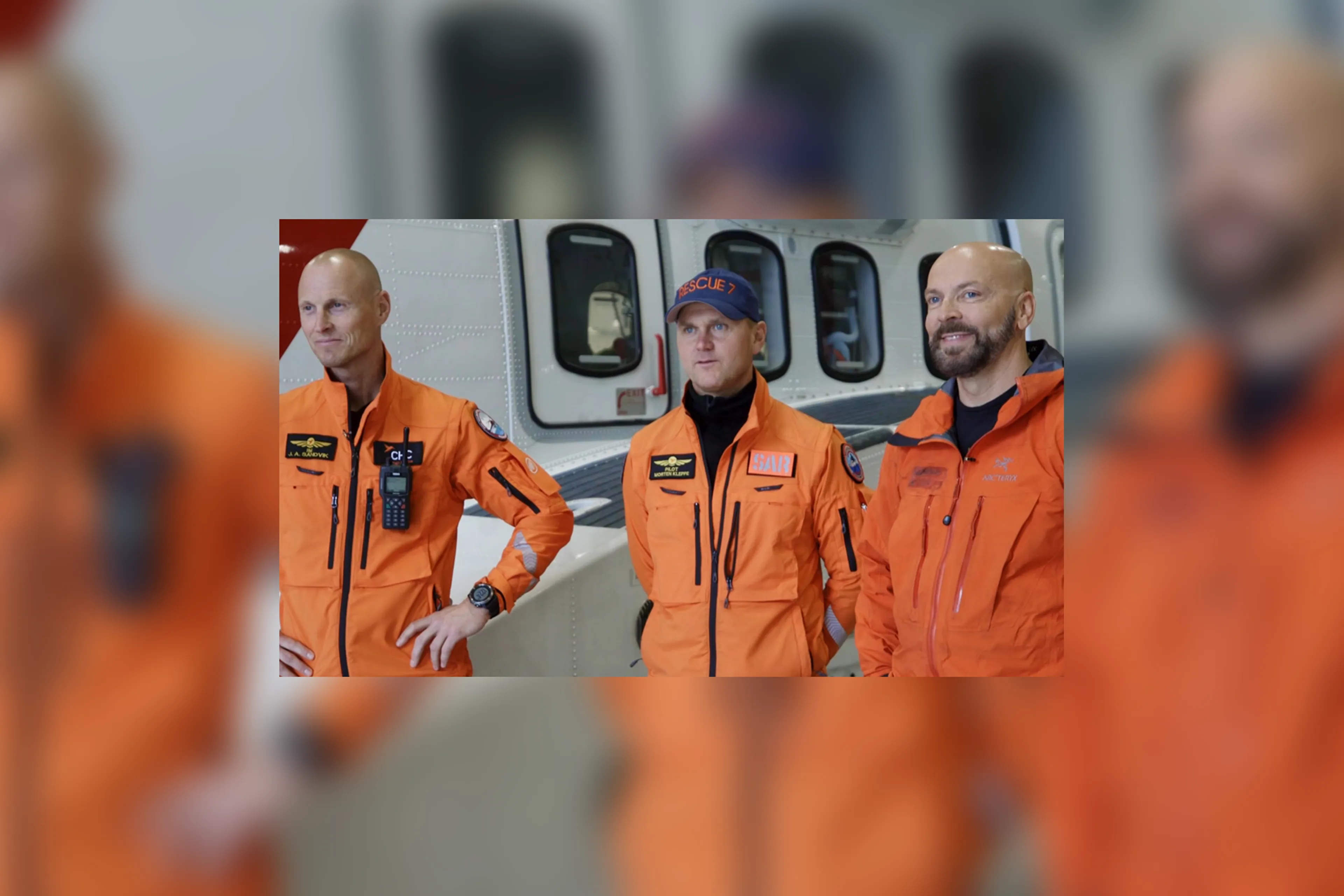 En gruppe menn i oransje kjeledresser