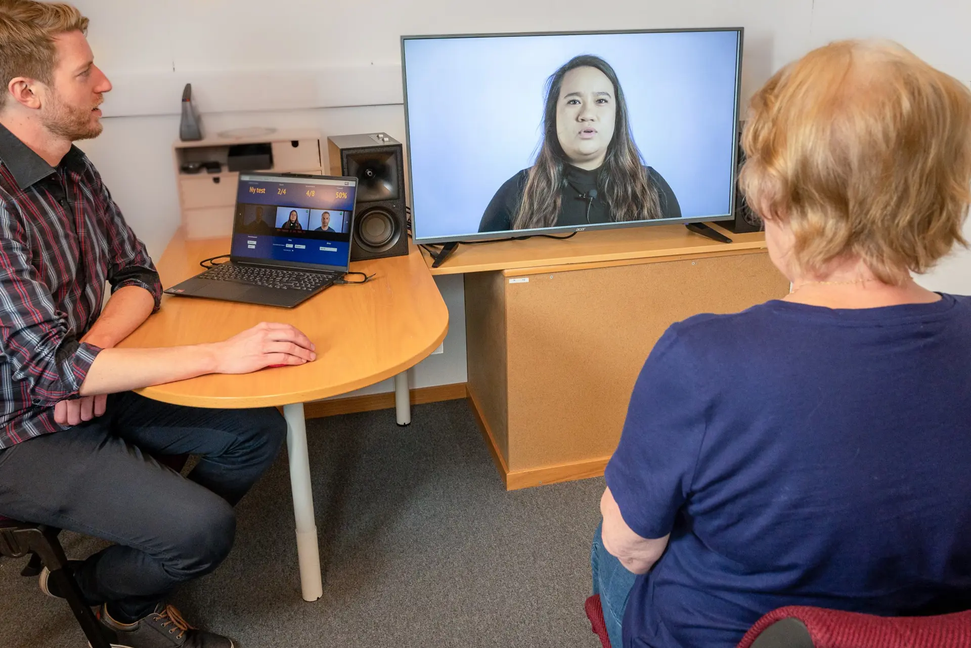 En mann og en kvinne som sitter ved et skrivebord og ser på en datamaskin