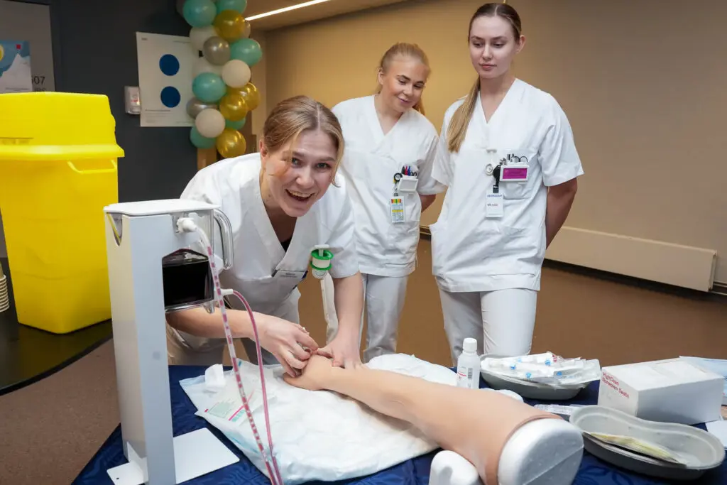 En gruppe mennesker i hvite laboratoriefrakker som står ved siden av en pasient
