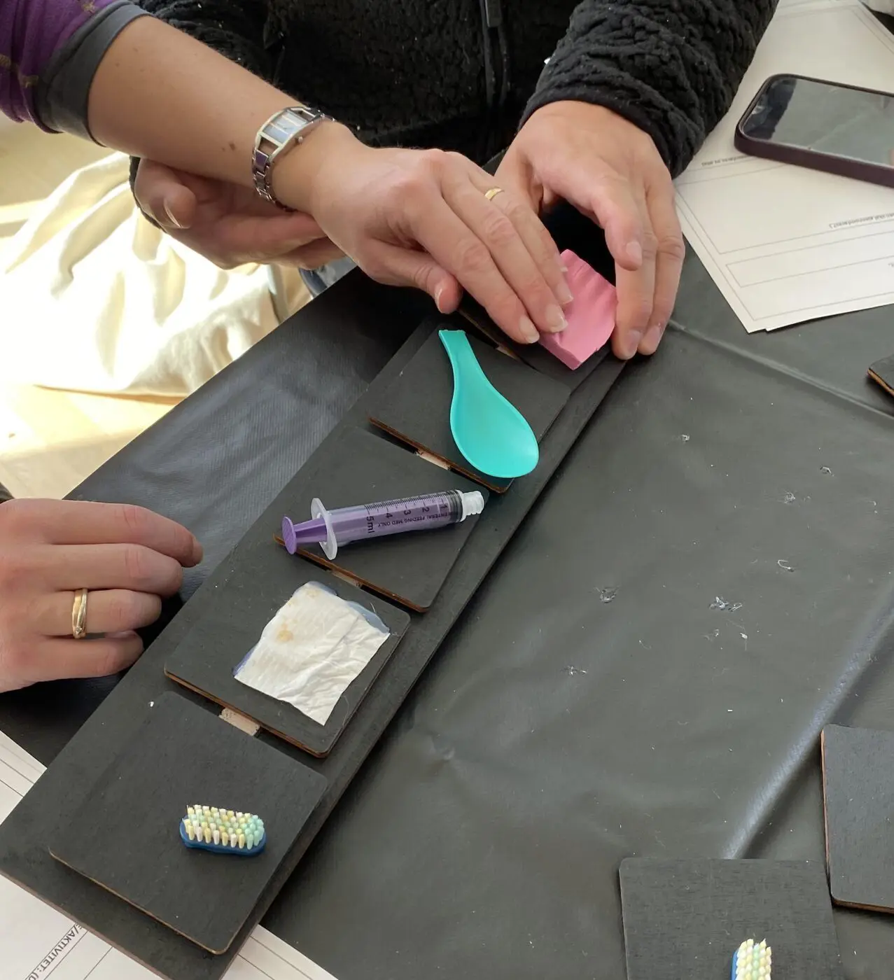 To personer ved et bord med ymse gjenstander