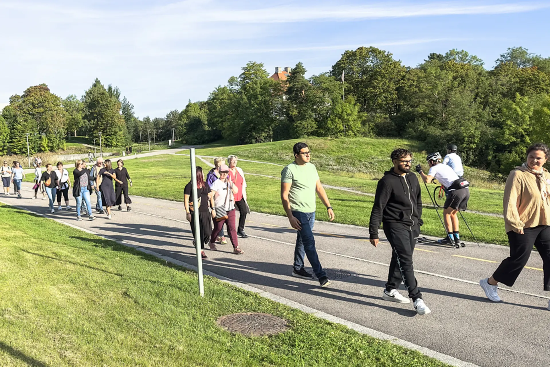 Folk som går i landlige omgivelser mens sola skinner