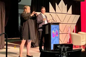 En mann og kvinne som står på en scene med en mikrofon