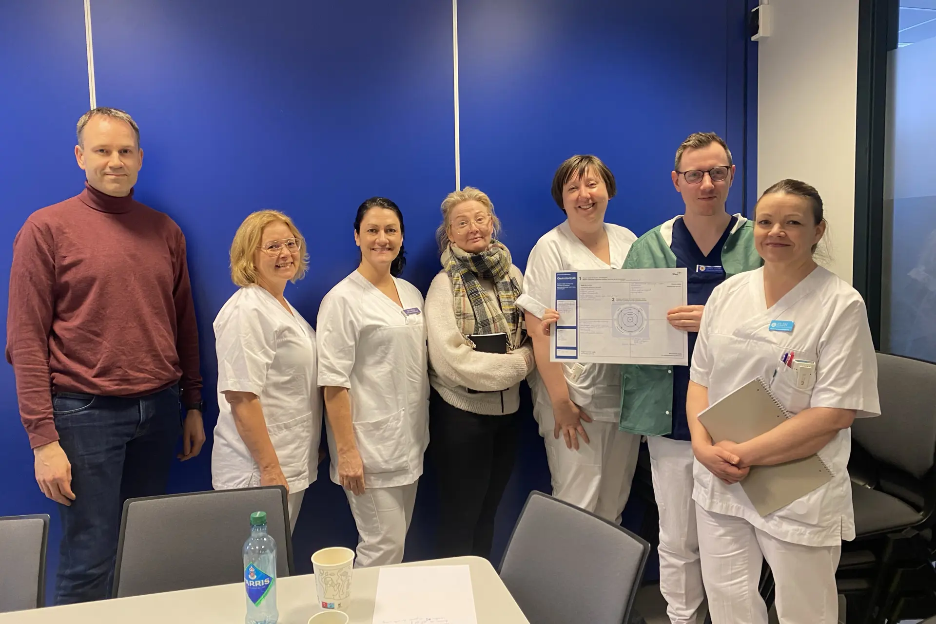 En gruppe personer rundt et arbeidsbord
