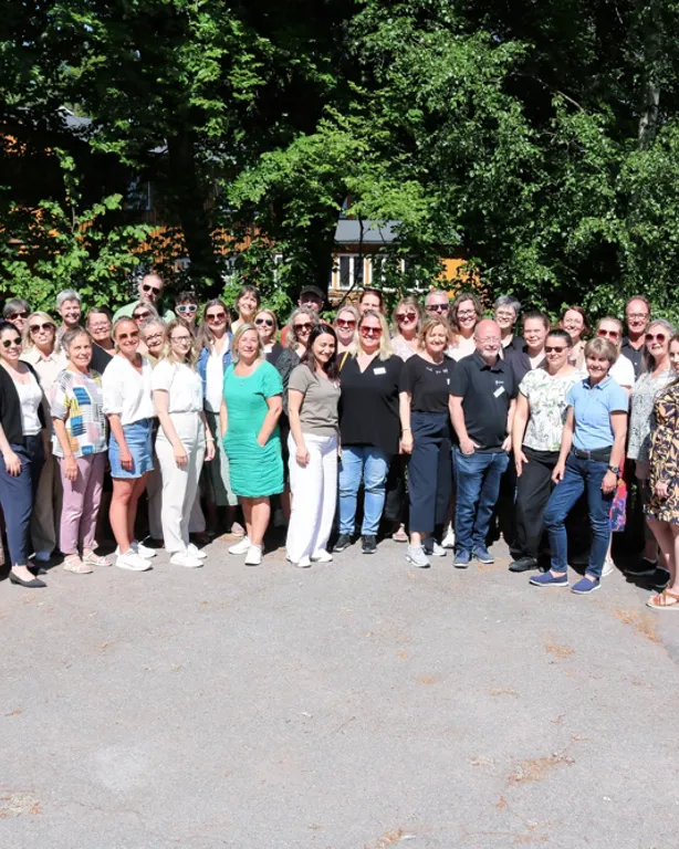 Stor gruppe mennesker som poserer for fotografen