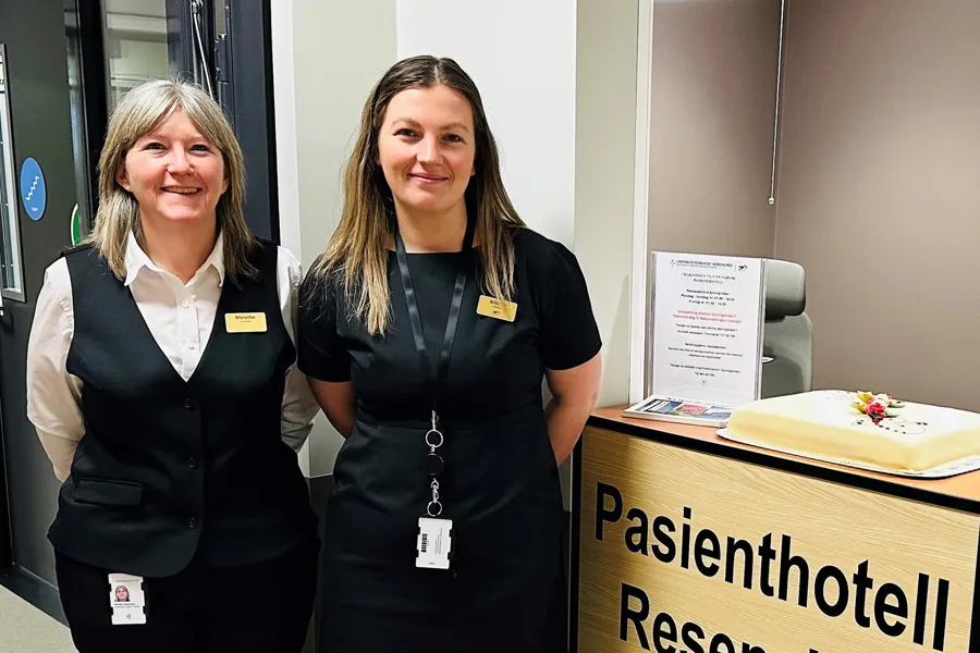 Et par kvinner som står ved siden av en kake