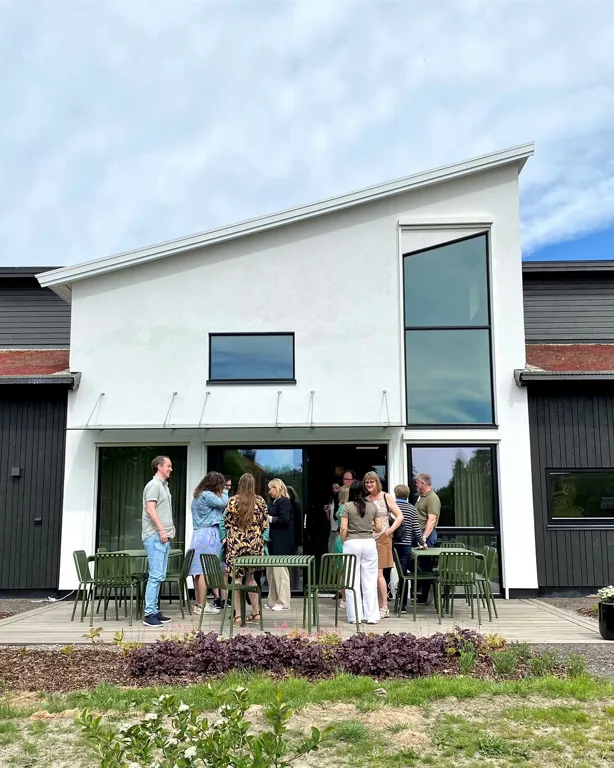 En gruppe mennesker som står utenfor et hus