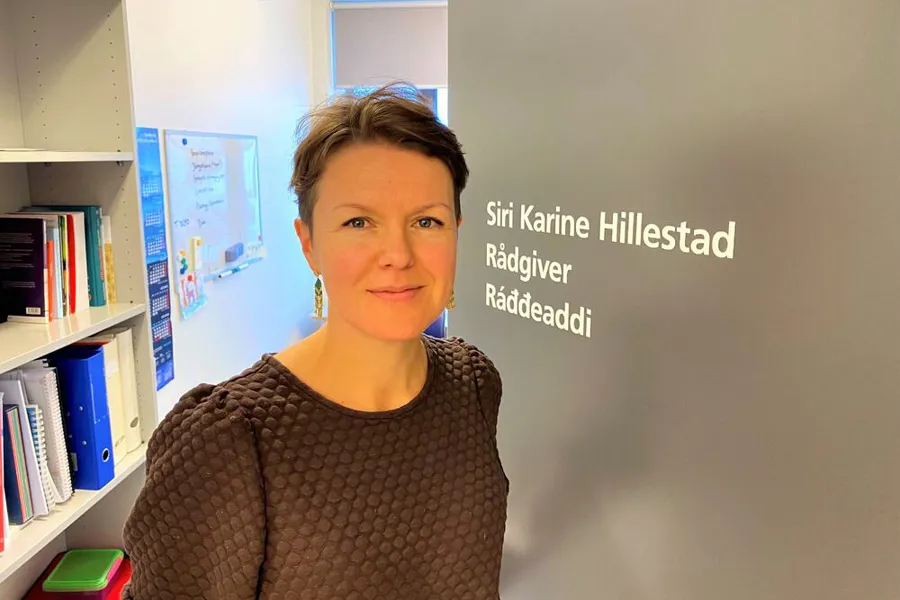 Kvinne som står foran en bokhylle