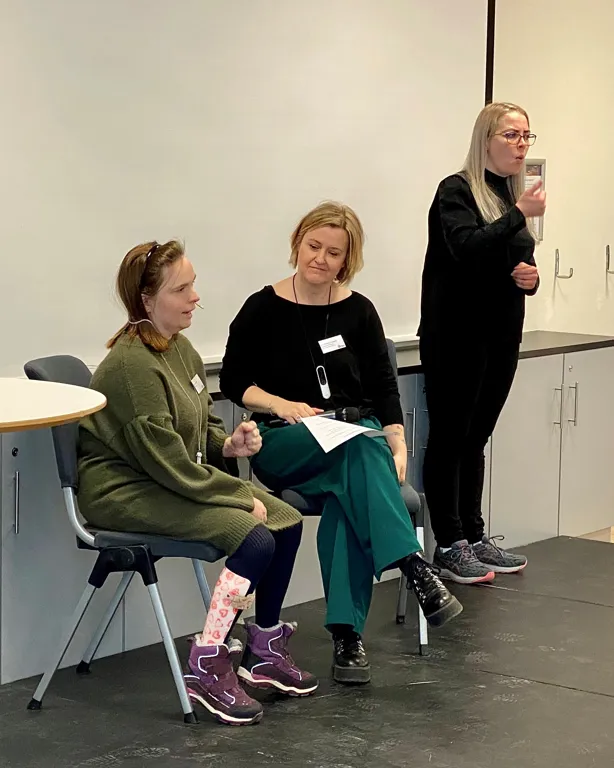 Tre kvinner , hvorav to sitter