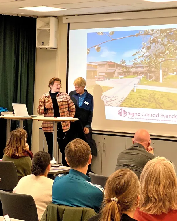 En gruppe mennesker foran en projektorskjerm