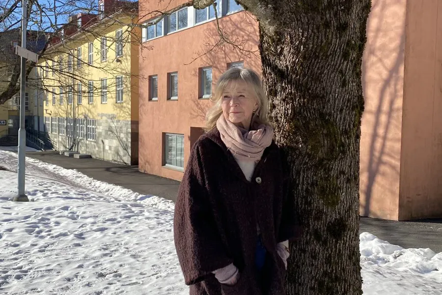 En kvinne som står ved siden av et tre