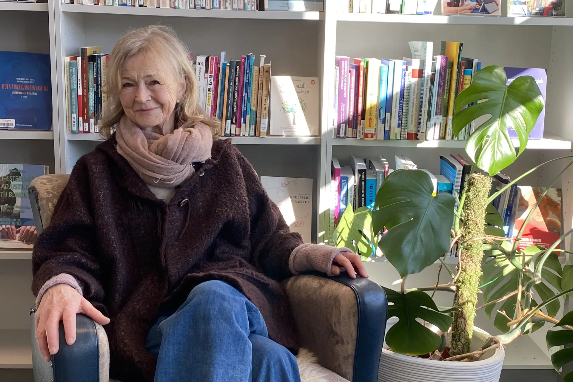 En kvinnne som sitter foran en boksamling