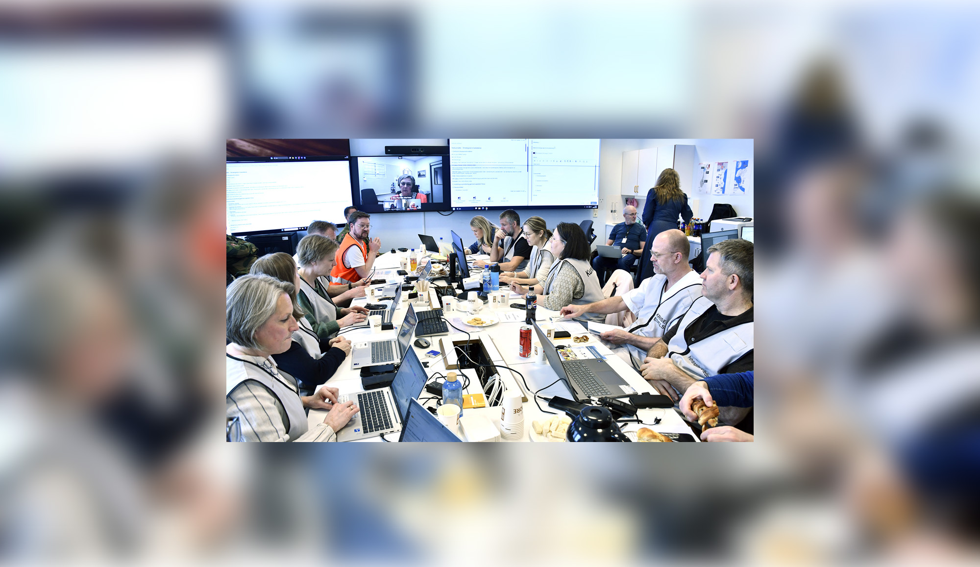 En gruppe mennesker som sitter rundt et bord med bærbare datamaskiner