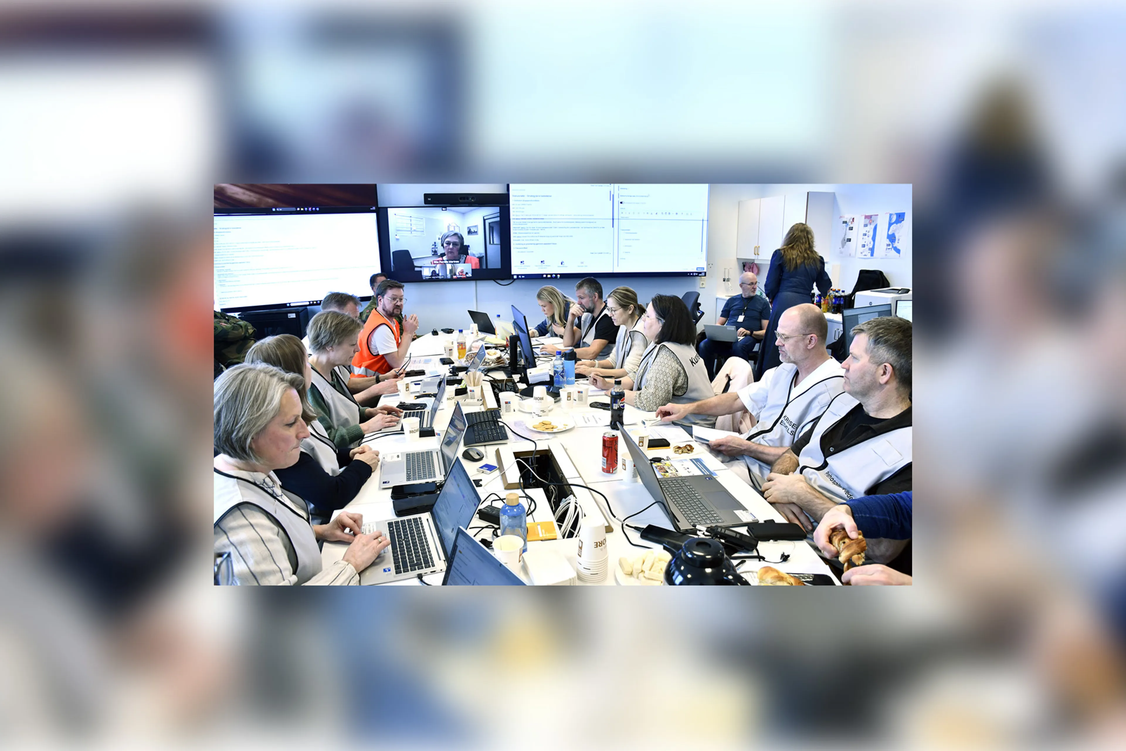 En gruppe mennesker som sitter rundt et bord med bærbare datamaskiner