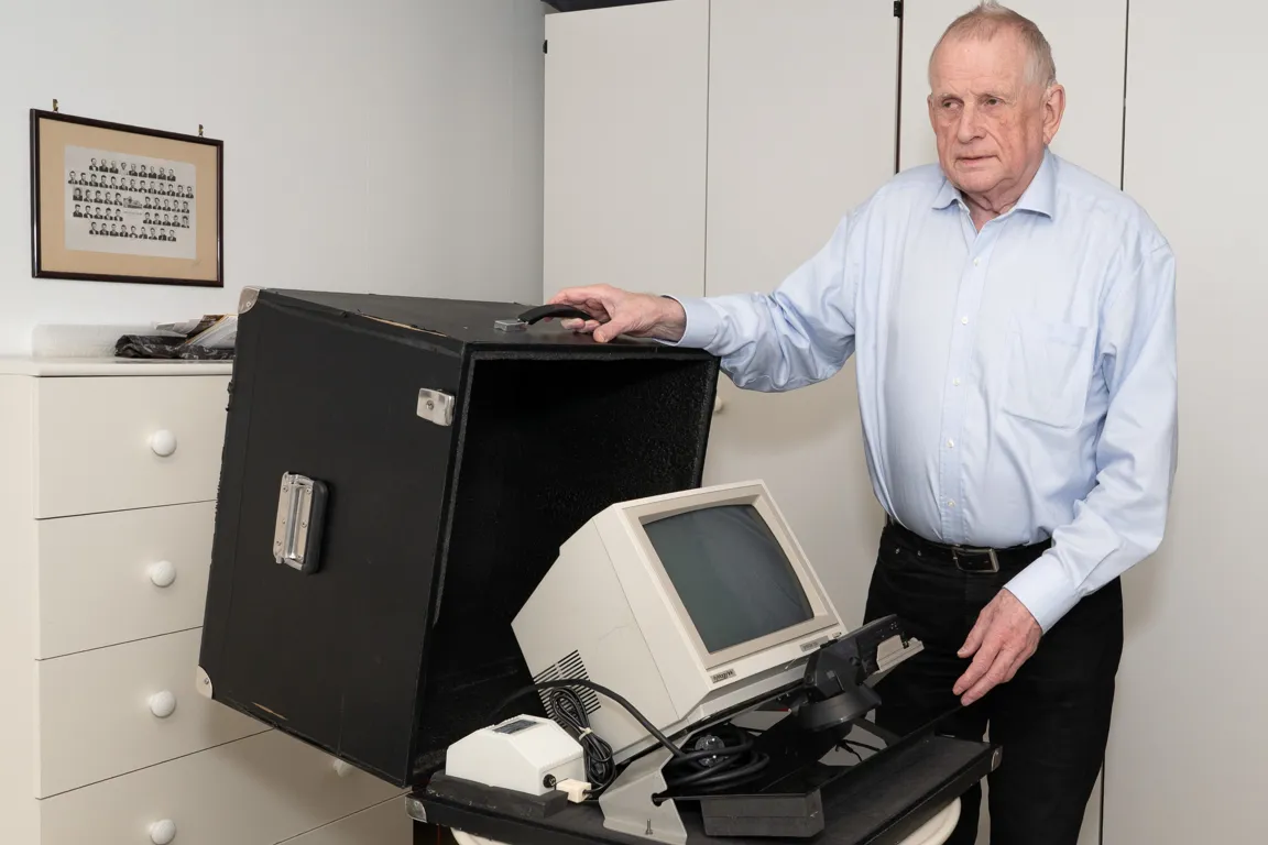 En mann som står ved siden av en datamaskin