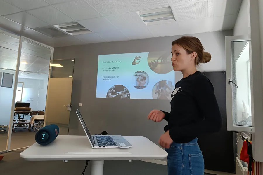 En person som står ved siden av en bærbar datamaskin