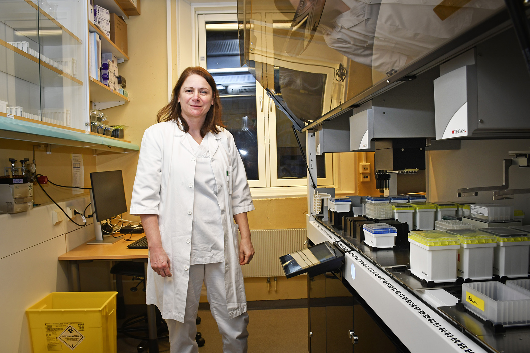 En kvinne i hvit arbeidsantrekk som står i et lager