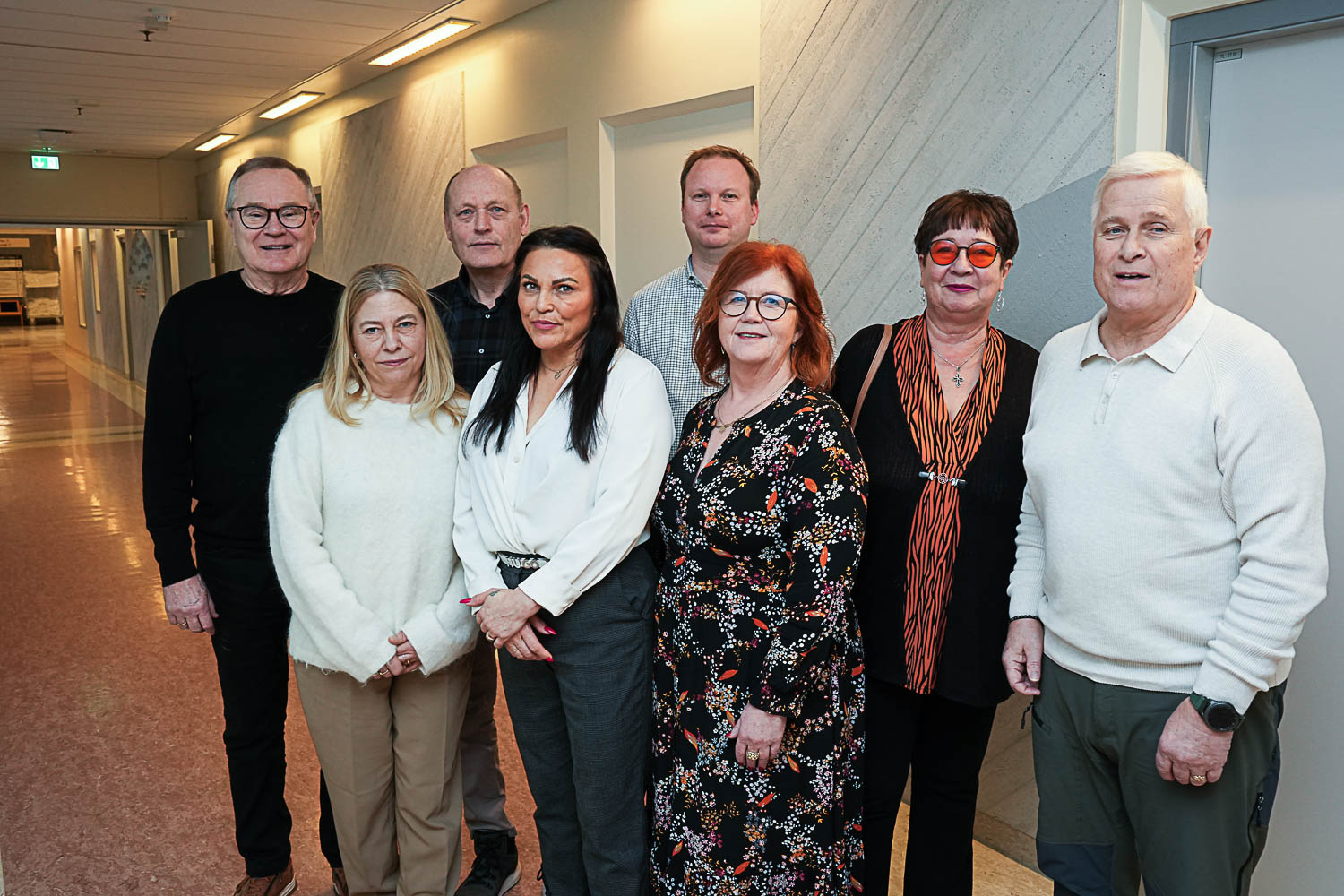 Fire  kvinner og fire menn som poserer for fotografen