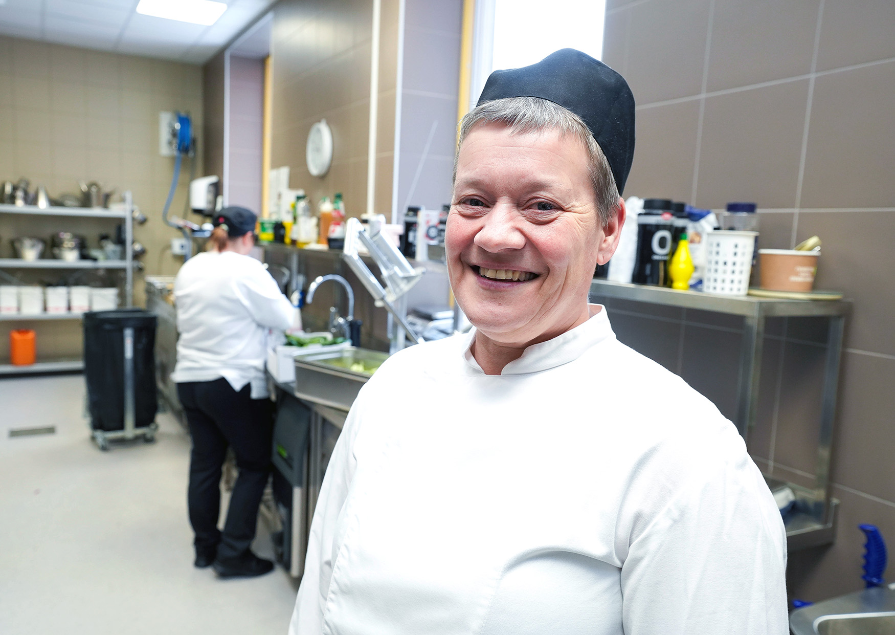 En mann som smiler på kjøkkenet