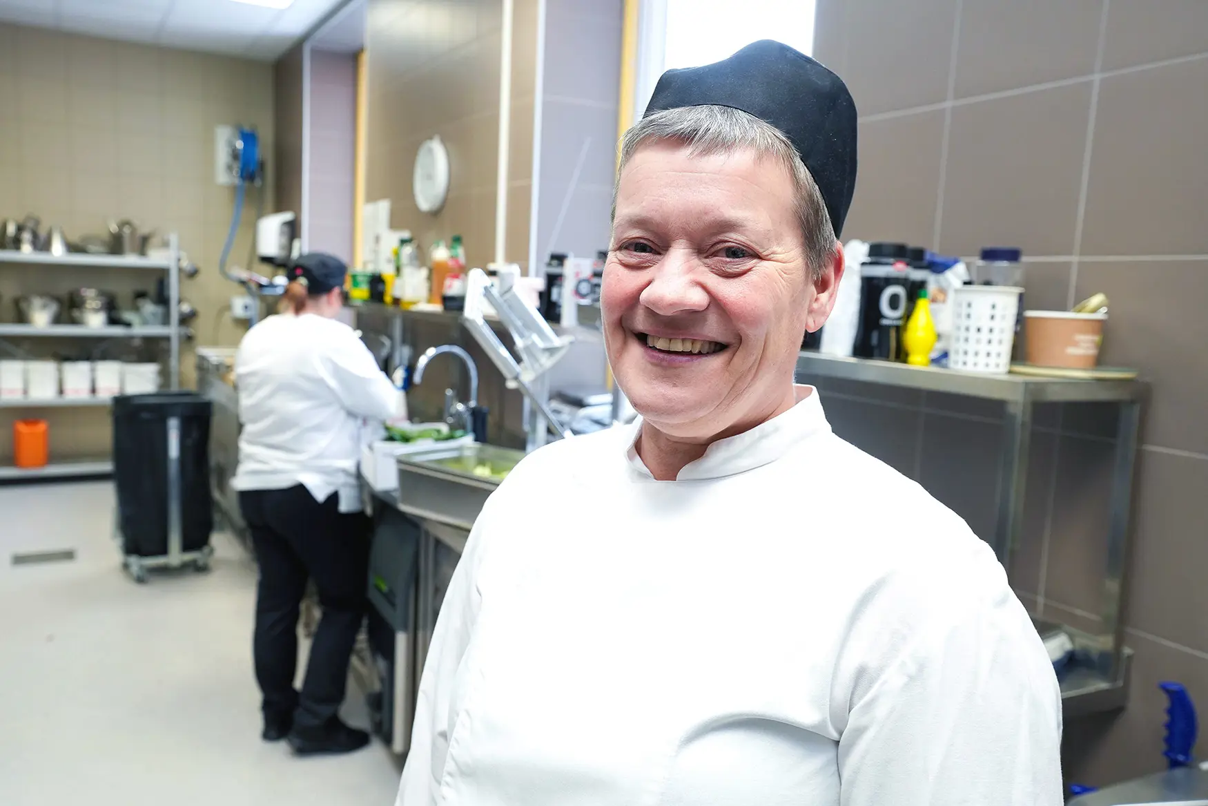 En mann som smiler på kjøkkenet