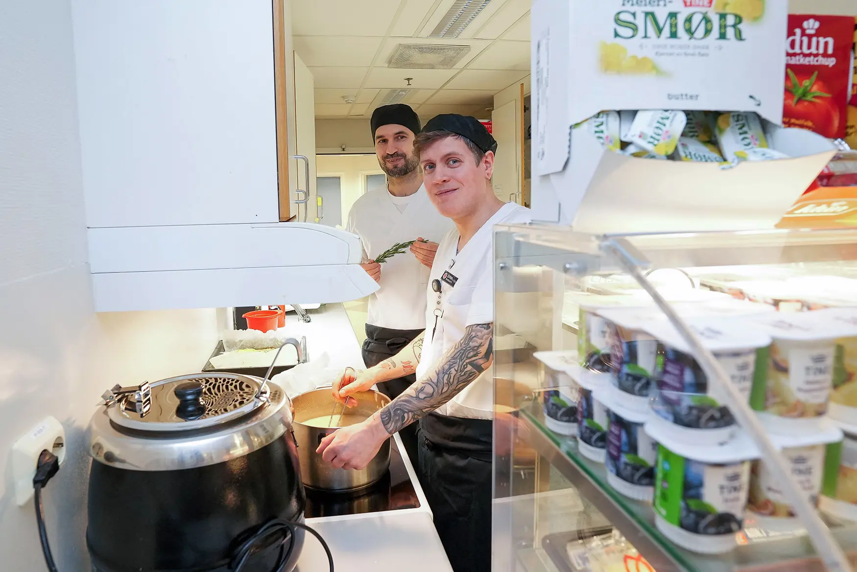 Et par menn står på kjøkkenet