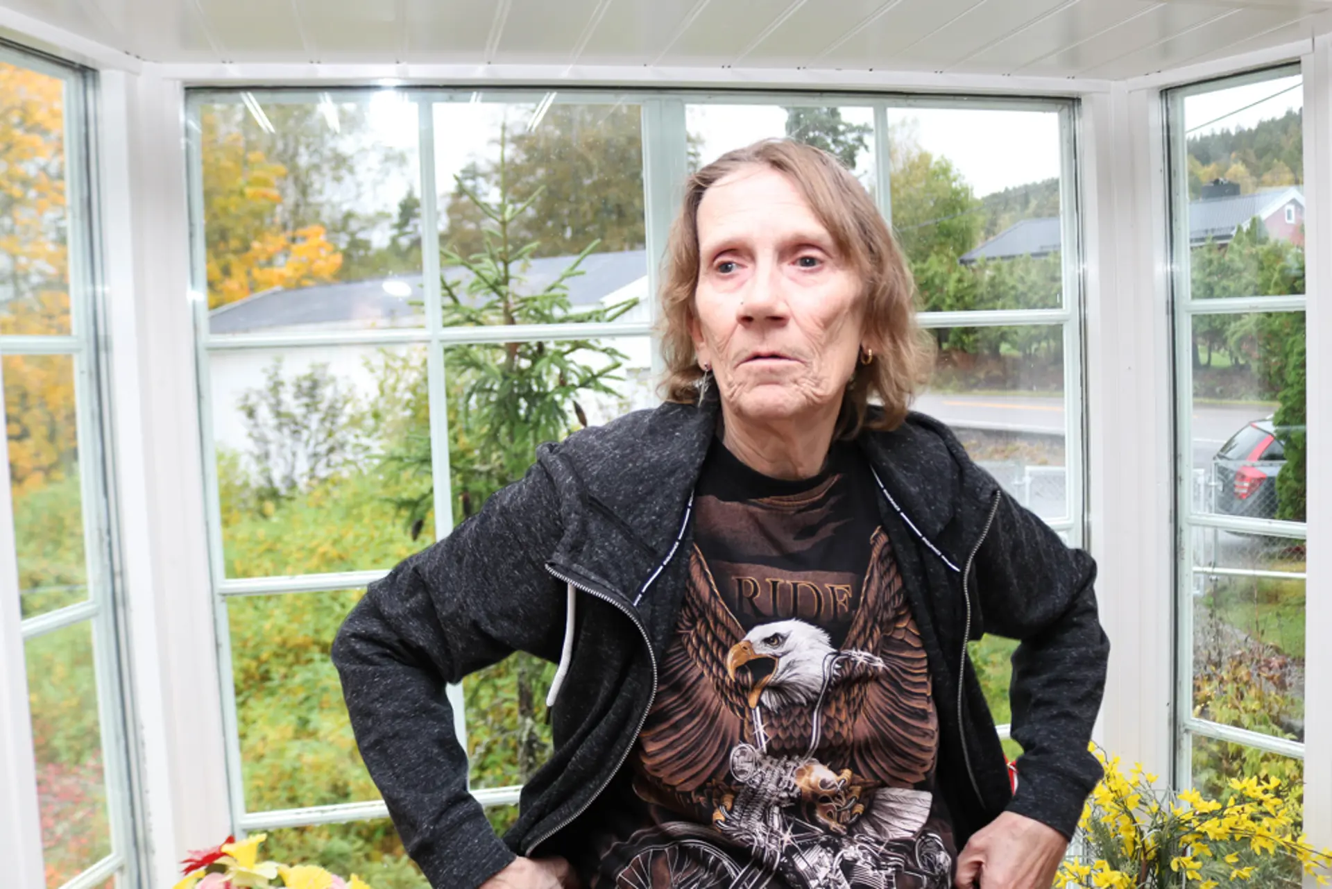 Døvblind dame står i et karnappvindu