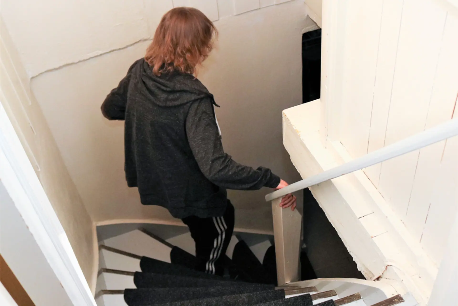 Døvblind kvinne går ned en trappegang til kjeller