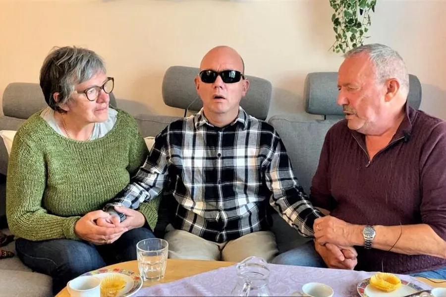 Tre voksne personer i en sofa