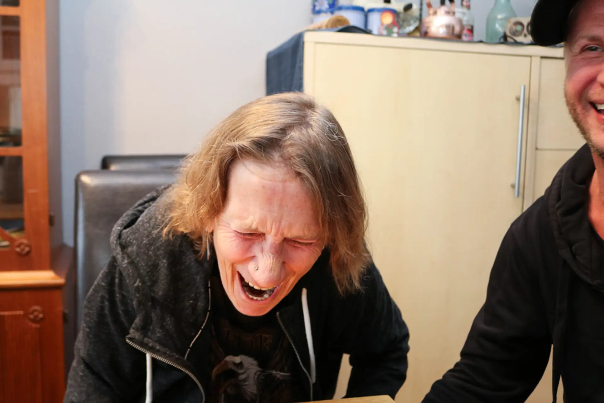 Døvblind dame skrattler sammen med sin tegnspråktolk