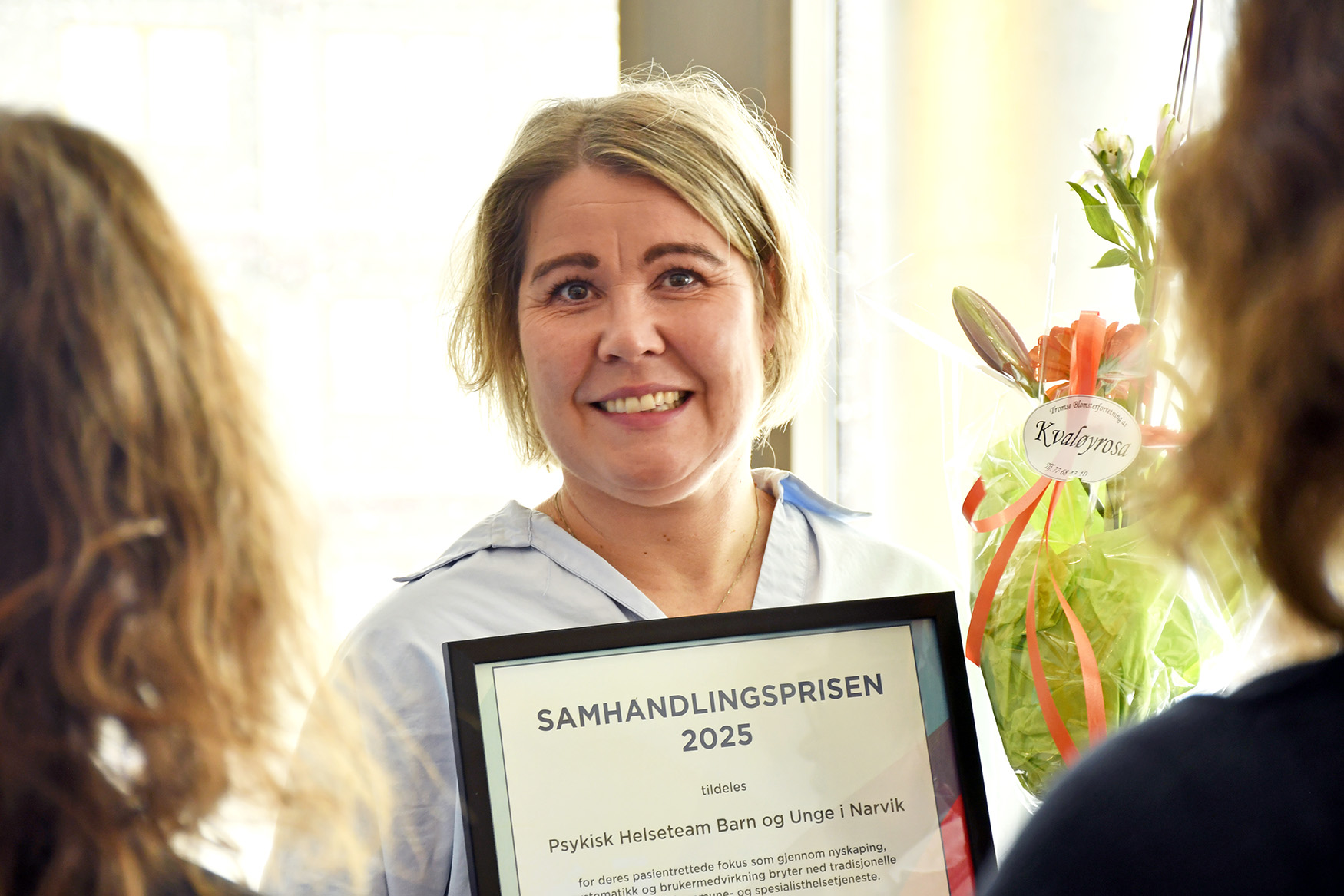 En kvinne som smiler til kameraet