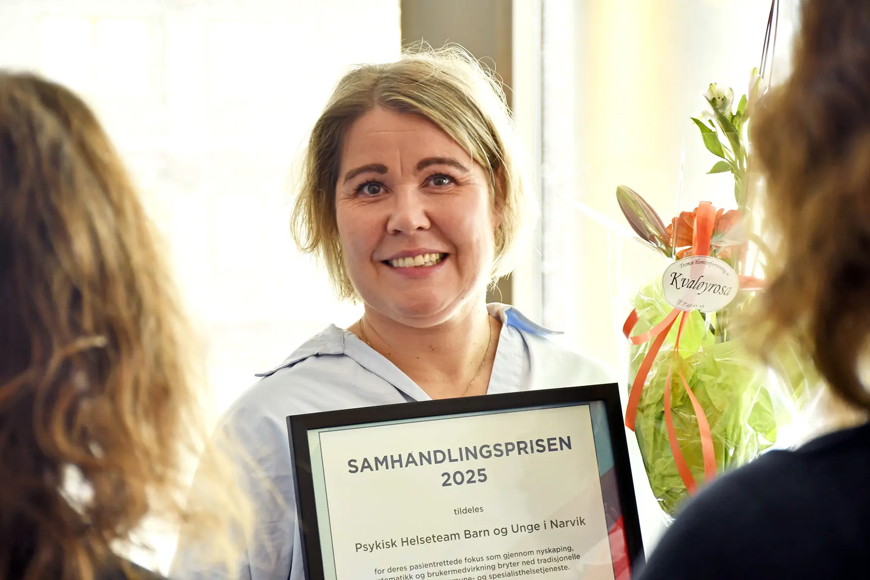En kvinne som smiler til kameraet