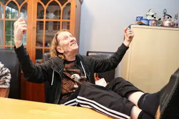 Smilende kvinne med beina på bordet