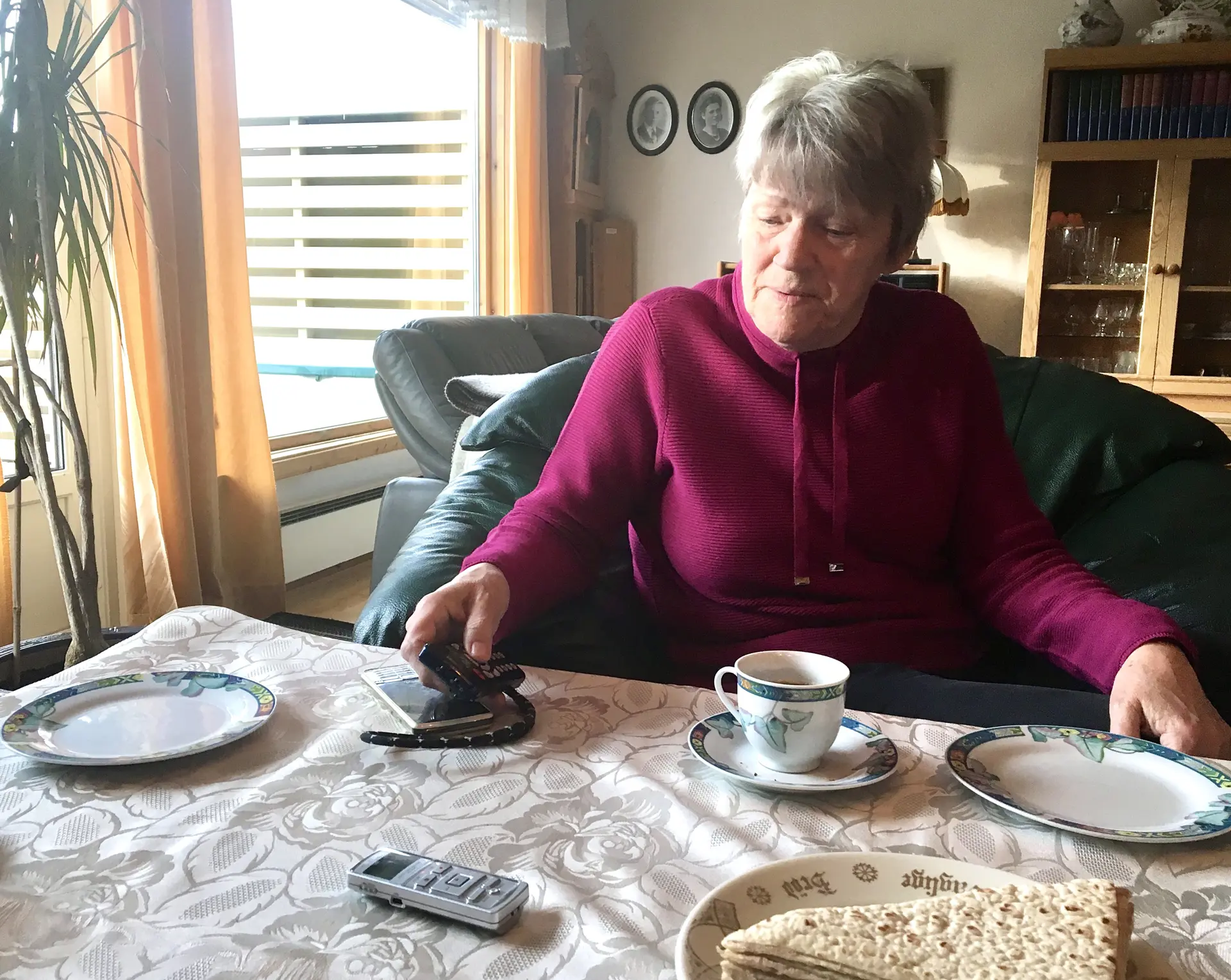 En kvinne som sitter ved et bord ned lefser og kaffe