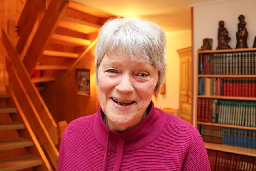 Kvinne i et privat hjem med mange bøker