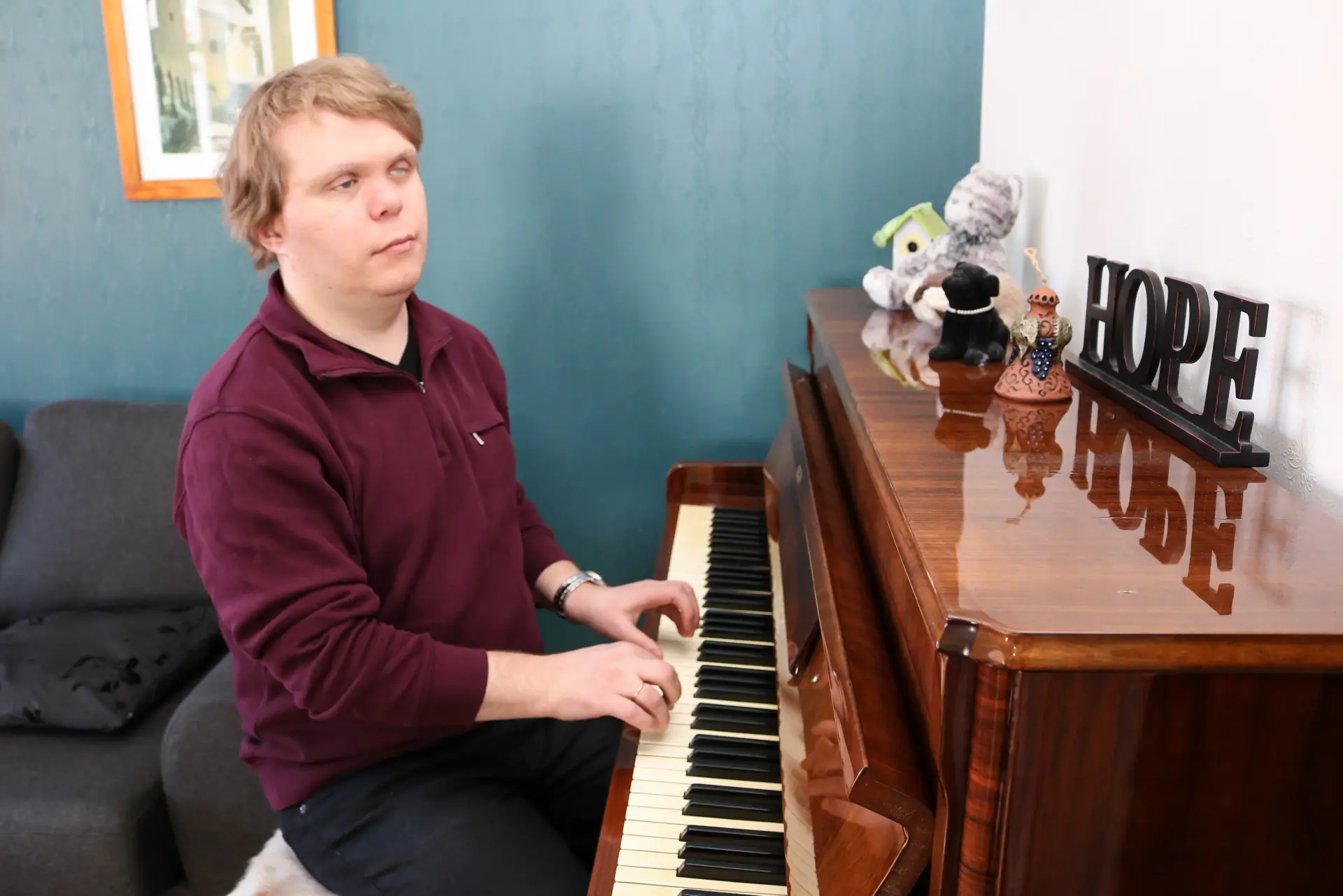 En mann som sitter ved et piano