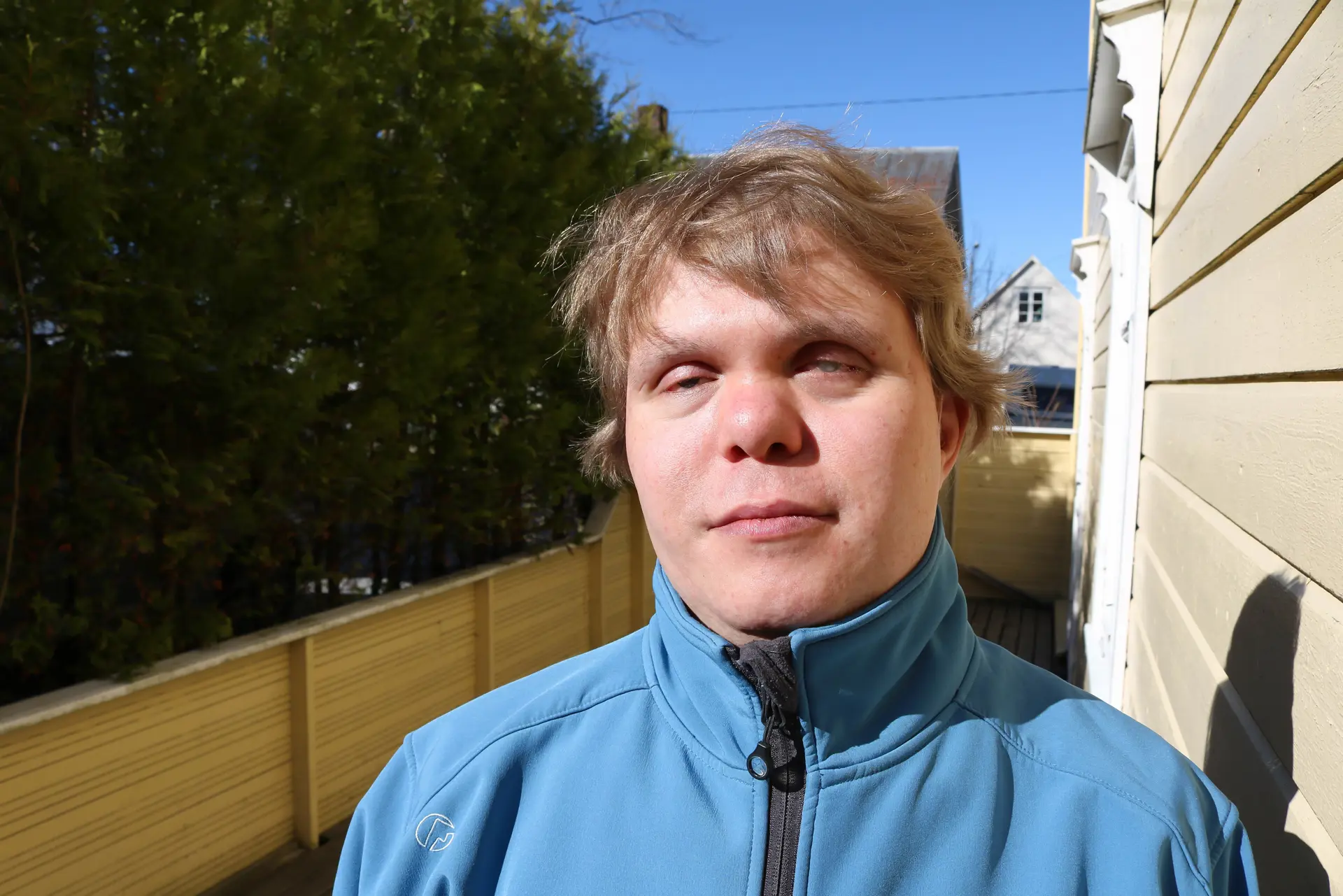 En mann foran gjerde og hekk