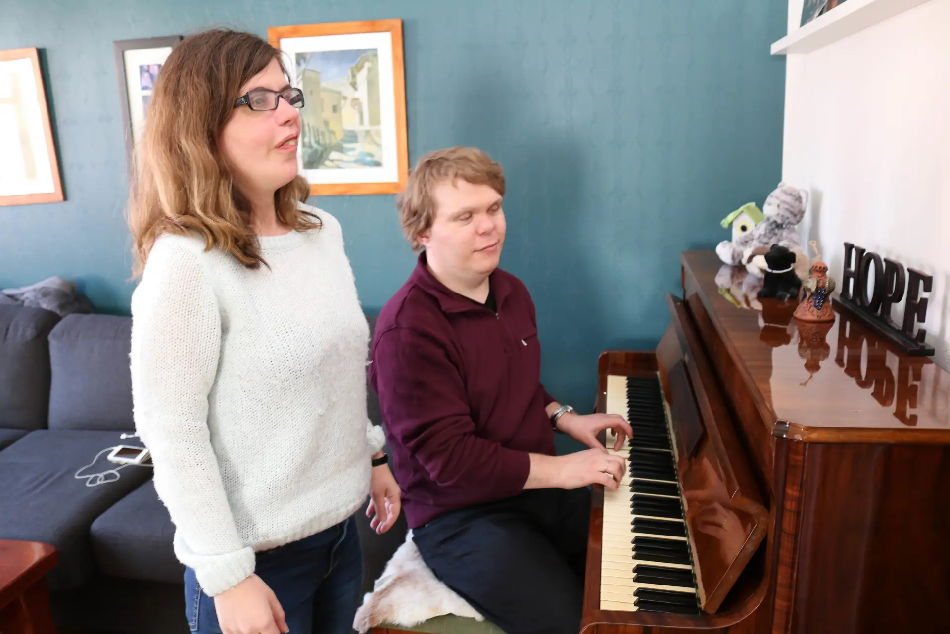 En syngende kvinne og en mann som spiller piano