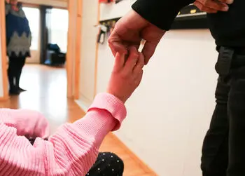 Hendene til far og datter møtes, lengre fremme synes mor.