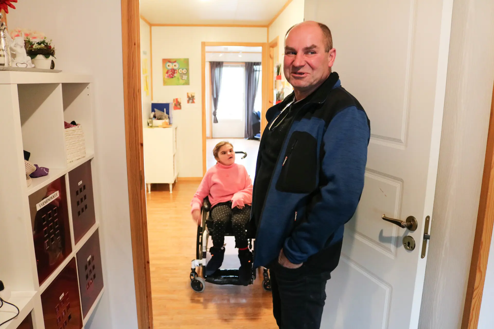 En voksen mann som står foran en ung kvinne i rullestol