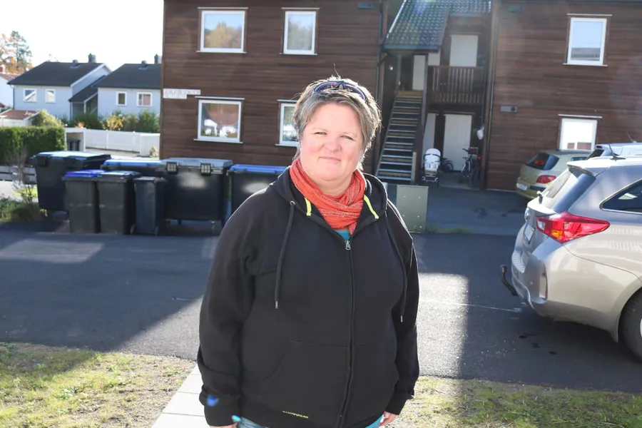 En kvinne som står foran en vei i et boligfelt