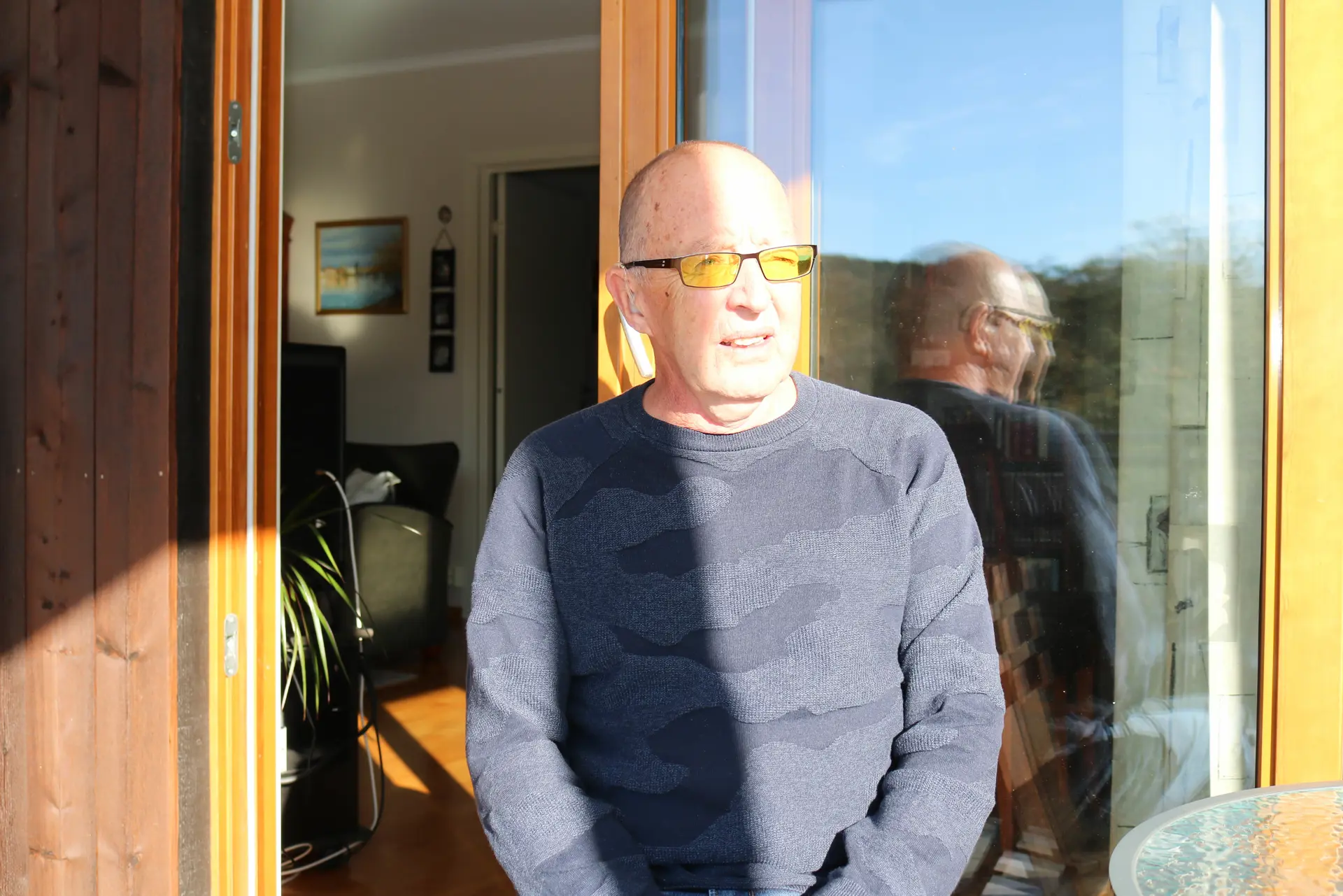 En person som er utenfor et hus i sola